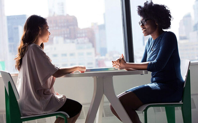 Two women sitting at a table talking